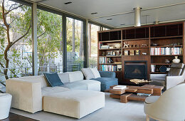 Living room in natural shades with glass walls and fitted shelving