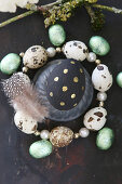 Easter egg painted black and gold in circlet of quail eggs