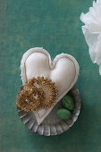 Golden wreaths on fabric heart in flan tin