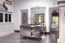 Mobile stainless steel island, white sideboard and French wall mirror in the kitchen