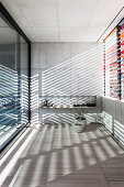Venetian blind made of powder-coated aluminum as a contrast to the concrete walls and travertine tiles