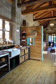 Kitchen in converted barn with concrete wall and wooden floor