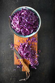 Sliced red cabbage in a bowl on a wooden board
