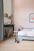 Hellgraues Bett und Konsole im Mädchenzimmer mit rosa Wand