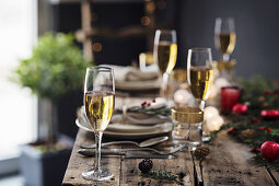 Champagnergläser auf weihnachtlich gedecktem Holztisch