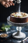 Orange rose and pistachio cake with sugar dust on the top