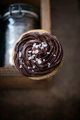 A biscuit with chocolate butter cream and sugar sprinkles (vegan)