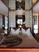 Schlittenbett aus Mahagoniholz in elegantem Schlafzimmer mit verspiegelter Decke