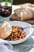 Lamb mince with vegetables, kidney beans and bread on an outdoor table