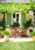 Red garden furniture in seating area outside French stone house