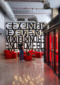 Red hexagonal pouffes in hotel lobby