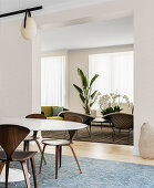 Ovaler Esstisch mit Designerstühlen vor Durchgang, Blick in Lounge