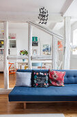 Blue sofa in front of half-timber frame with view into dining room