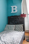 Buchstabe überm mit Tafellack gestrichenen Kinderbett
