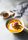 Creamy yellow beetroot soup with radishes and chickpeas