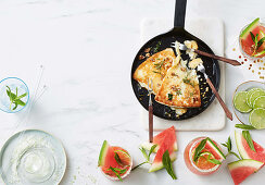 Gebratener griechischer Käse mit Honig, Oregano und Walnüssen, dazu Wassermelonen-Mojitos