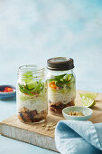 Chicken fillets with chilli jam, vermicelli and salad in glass jars