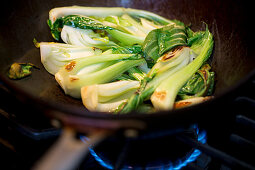 Fried bok choy in a wok