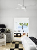 View of chest of drawers with mother-of-pearl inlays in the bedroom, living room in the background and sea view