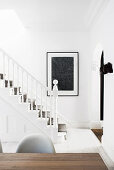 Blick auf weiß gestrichene Holztreppe mit Teppich