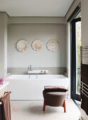 Designer-Badewanne und Polsterhocker im Badezimmer mit Terrassenzugang