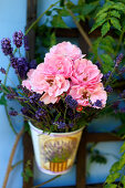 Hängender, kleiner Eimer mit Rosen und Lavendelblüten