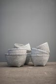Stacked white baskets in front of grey wall
