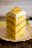 A slice of three-layer lemon cake with frosting