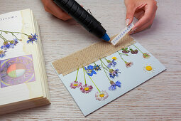 Postkarte mit gepressten Blumen und fransigem Jutestoff