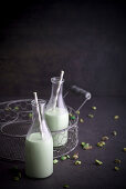 Homemade pistachio milk with straws in bottles