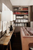 Modern table lamps on rustic table in front of bookshelves