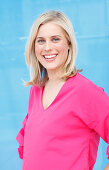 A young blonde woman wearing a pink top