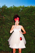 A young woman wearing a white tutu dress with red hair accessories