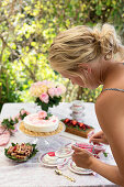 A summer table laid with redcurrant cakes and desserts