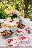 A table laid in a garden with redcurrant cake and desserts