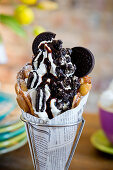 A bubble waffle with frozen yoghurt, Oreo cookies, Oreo popcorn and chocolate sauce