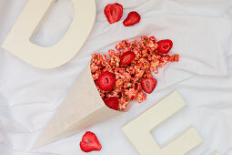 A paper cone with strawberry popcorn (seen from above)