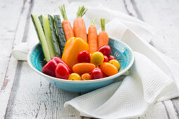 A bowl of carrots, pepper, cucumber and tomatoes