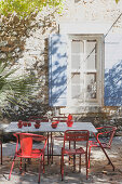 Tisch mit Vintage Stühlen auf Terrassenplatz vor provenzalischem Haus