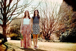 Two young women in a park wearing summer outfits