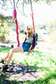 A young blonde woman on a swing