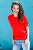 A brunette woman wearing a short-sleeved red jumper
