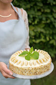 A festively dressed woman serving banana and cream cheese cake