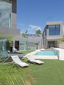 Clipped lawn surrounding architect-designed house with swimming pool