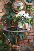 Bouquet of anemones, carnations and ivy on old washstand