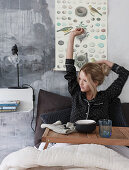 Woman wearing pyjamas stretching in bed with breakfast tray