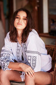 A brunette woman wearing a printed ethnic blouse