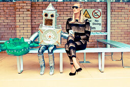 A blonde woman wearing a black-and-gold striped outfit next to a child dressed as a robot