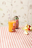 ACE vitamin juice for children in a colourful glass with a straw