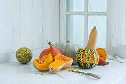 Various pumpkins on a rustic kitchen counter